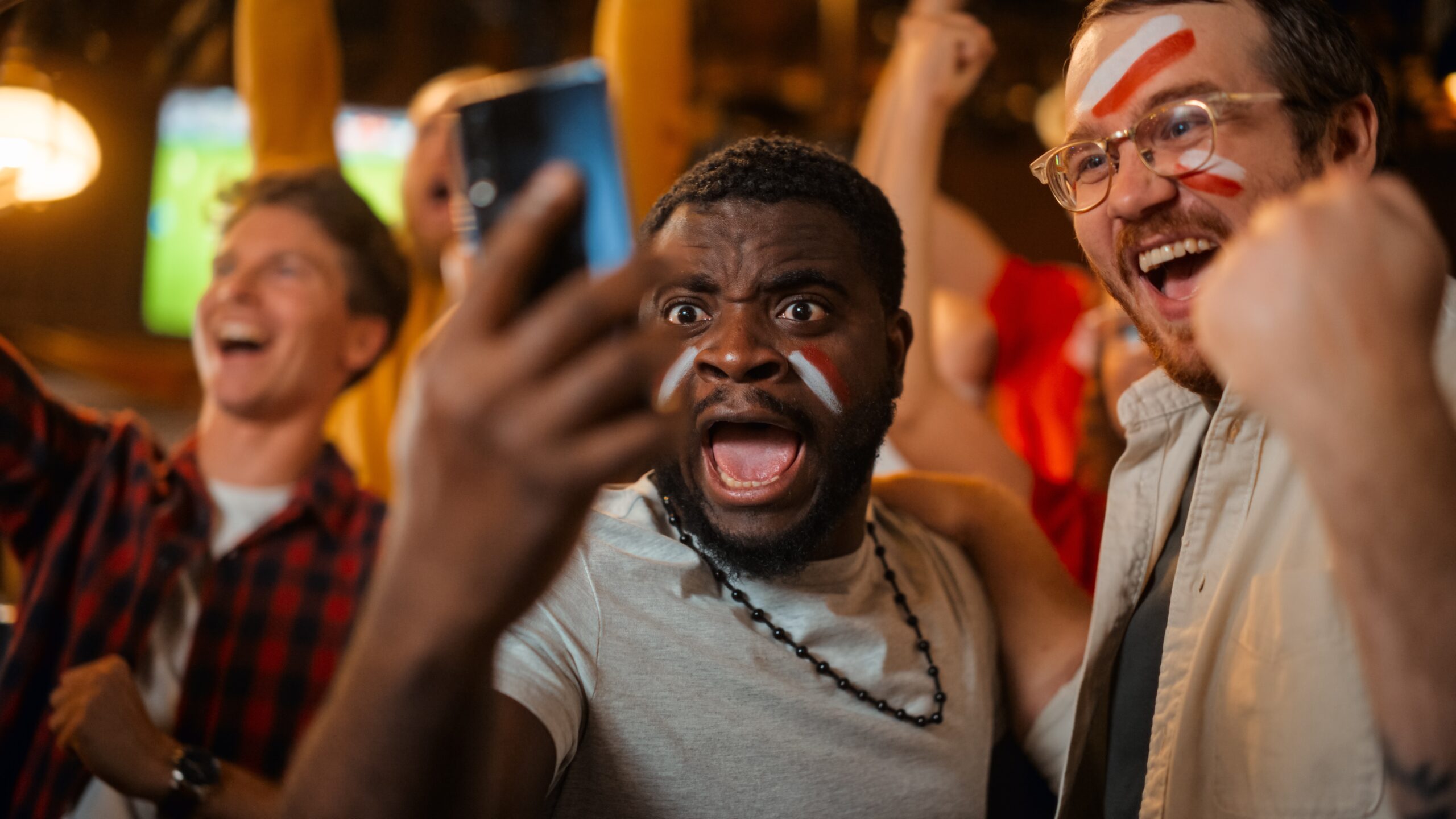 Portrait,Of,Two,Excited,Diverse,Friends,Holding,A,Smartphone,,Celebrate